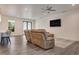 Bright living room featuring a comfortable sofa, ceiling fan, and vinyl plank flooring at 7344 Manthey Ave, North Port, FL 34291