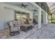 Spacious covered patio with comfortable seating, ceiling fans, and a view of the backyard at 7344 Manthey Ave, North Port, FL 34291