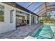 Inviting pool area with a covered patio, outdoor seating, and a lush green view at 7344 Manthey Ave, North Port, FL 34291