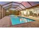 Screened pool area featuring a pool and hot tub with brick pavers and lounge seating at 7344 Manthey Ave, North Port, FL 34291