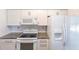 This bright kitchen features white appliances, granite countertops, and subway tile backsplash at 963 Kennwood Nw Ter, Port Charlotte, FL 33948