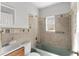 Bathroom features tiled walls, a bathtub, and a wood vanity with sink at 102 21St Ne St, Bradenton, FL 34208