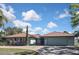 Well-maintained single-story home with a copper-colored metal roof, a two-car garage, and beautiful landscaping at 104 Graham Se St, Port Charlotte, FL 33952