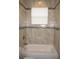 Tiled bathroom showing tub and shower combination featuring a shower head and grab bar for safety at 1182 Yorkshire St, Port Charlotte, FL 33952