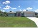 Charming single-story home with manicured lawn, neutral paint, and attached garage with an inviting exterior elevation at 1182 Yorkshire St, Port Charlotte, FL 33952