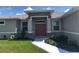 Inviting front entrance with stone accents, a charming red double door and lovely landscaping at 1182 Yorkshire St, Port Charlotte, FL 33952