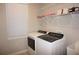 Bright laundry room with modern washer and dryer, storage shelves, and natural light from the window at 1182 Yorkshire St, Port Charlotte, FL 33952