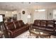 Bright living room featuring leather sofas, open to the kitchen, and modern lighting at 1182 Yorkshire St, Port Charlotte, FL 33952
