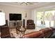 Comfortable living room with sliding glass doors, entertainment center, and relaxed seating arrangement at 1182 Yorkshire St, Port Charlotte, FL 33952