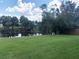 Beautiful view of the pond with tropical trees and lush lawn, perfect for relaxation and nature enjoyment at 1182 Yorkshire St, Port Charlotte, FL 33952