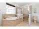 Bright bathroom with a soaking tub, separate shower, and ample natural light from a large window at 145 Brig E Cir, Placida, FL 33946