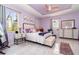 Charming bedroom with serene lavender walls, tray ceiling, and abundant natural light from multiple windows at 145 Brig E Cir, Placida, FL 33946