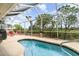 Relaxing screened-in pool area featuring a sparkling pool, lounge chairs, and lush greenery at 145 Brig E Cir, Placida, FL 33946