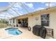 Backyard with private screened pool, patio area, grill, and view of the home's covered outdoor seating at 145 Brig E Cir, Placida, FL 33946