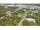 Aerial view of neighborhood homes nestled among trees with commercial spaces in the distance at 15172 Mcgraw Ave, Port Charlotte, FL 33953