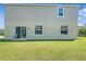 Back exterior of home with sliding glass door and a spacious yard at 15172 Mcgraw Ave, Port Charlotte, FL 33953