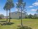 Expansive backyard with tall palm trees and a verdant lawn at 15172 Mcgraw Ave, Port Charlotte, FL 33953