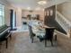 Open-concept dining area with stylish seating, modern decor, adjacent to a well-equipped kitchen and staircase at 15172 Mcgraw Ave, Port Charlotte, FL 33953
