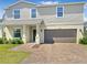 Inviting two-story home featuring a brick driveway, neutral siding, and an attached two-car garage at 15172 Mcgraw Ave, Port Charlotte, FL 33953