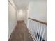 Upstairs hallway with carpet, white walls, white banister, and closet doors at 15172 Mcgraw Ave, Port Charlotte, FL 33953