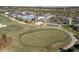 This is a bird's eye view of golfers on a green adjacent to a clubhouse with a pool at 15931 Sugar Hill Dr, Punta Gorda, FL 33982