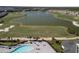 An aerial view of a pool, driving range, and lake in a golf course community at 15931 Sugar Hill Dr, Punta Gorda, FL 33982