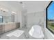 Spa-like bathroom with a soaking tub, dual vanities, and marble accents, creating a serene retreat at 17476 Vellum Cir, Punta Gorda, FL 33955