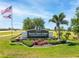 Entrance to the deed restricted community of Burnt Store Lakes with manicured landscaping and flags at 17476 Vellum Cir, Punta Gorda, FL 33955