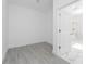 Image of a vacant room with light gray wood-look tile flooring, bright white walls and trim, and doorway to the bathroom at 17476 Vellum Cir, Punta Gorda, FL 33955
