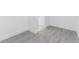 Image of a vacant room with light gray wood-look tile flooring, bright white walls and trim, and doorway to another room at 17476 Vellum Cir, Punta Gorda, FL 33955