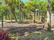 A colorful community playground featuring swings and a slide, nestled among shady trees, offering children a fun and safe play area at 17476 Vellum Cir, Punta Gorda, FL 33955