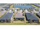 Aerial view of homes with screened patios and solar panels near a pond at 17860 Palmetto Pass Ln, Punta Gorda, FL 33982