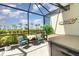 Charming screened lanai featuring a table, chairs, and a spa, surrounded by lush greenery and palm trees at 17860 Palmetto Pass Ln, Punta Gorda, FL 33982