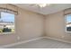 Bright bedroom featuring a ceiling fan, wood-look flooring, and two windows with exterior views at 18427 Goodman Cir, Port Charlotte, FL 33948