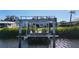 Private boat lift and dock on canal with house and manicured yard in the background at 18427 Goodman Cir, Port Charlotte, FL 33948