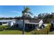 Home exterior boasting a screened-in lanai, a storage shed and beautifully manicured landscaping at 18427 Goodman Cir, Port Charlotte, FL 33948