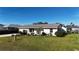 Well-maintained single-story home with tidy landscaping, a green lawn, and an attached garage at 18427 Goodman Cir, Port Charlotte, FL 33948