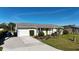 Lovely single-story home featuring an attached garage, neat landscaping, and a green front lawn at 18427 Goodman Cir, Port Charlotte, FL 33948