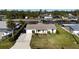 Charming waterfront home with attached garage, lush landscaping, and well-manicured lawn at 18427 Goodman Cir, Port Charlotte, FL 33948