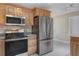 Well lit kitchen features light wood cabinets, stainless steel appliances and neutral color palette at 18427 Goodman Cir, Port Charlotte, FL 33948