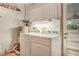 Laundry room with a washer, dryer, water heater, storage cabinets, and access to the backyard at 18427 Goodman Cir, Port Charlotte, FL 33948