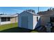 Exterior view of the white vinyl storage shed with metal roof in the well-maintained backyard at 18427 Goodman Cir, Port Charlotte, FL 33948
