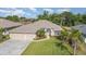 Beautiful single-story home featuring a manicured lawn, lush landscaping, and a three-car garage, creating curb appeal at 2132 Nuremberg Blvd, Punta Gorda, FL 33983