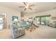 Spacious living room with carpet, a ceiling fan, a glass table, and a slider to the screened-in porch at 2132 Nuremberg Blvd, Punta Gorda, FL 33983