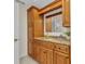 Bathroom vanity featuring wood cabinets, granite countertop, and a large framed mirror at 2350 W Marion Ave, Punta Gorda, FL 33950