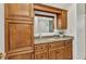 Bathroom vanity featuring wood cabinets, granite countertop, and a large framed mirror at 2350 W Marion Ave, Punta Gorda, FL 33950