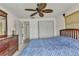 A cozy bedroom featuring a light blue comforter, wooden furniture, and ceiling fan at 2350 W Marion Ave, Punta Gorda, FL 33950