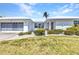 Single-story home featuring a white exterior, tidy landscaping, and a modern garage door at 2350 W Marion Ave, Punta Gorda, FL 33950