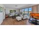 Bright living room featuring cozy seating, wood floors, and large windows with water views at 2350 W Marion Ave, Punta Gorda, FL 33950