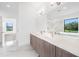 Bathroom features double sinks, quartz countertop, wood cabinets and a large window with a view at 24259 Peppercorn Rd, Punta Gorda, FL 33955